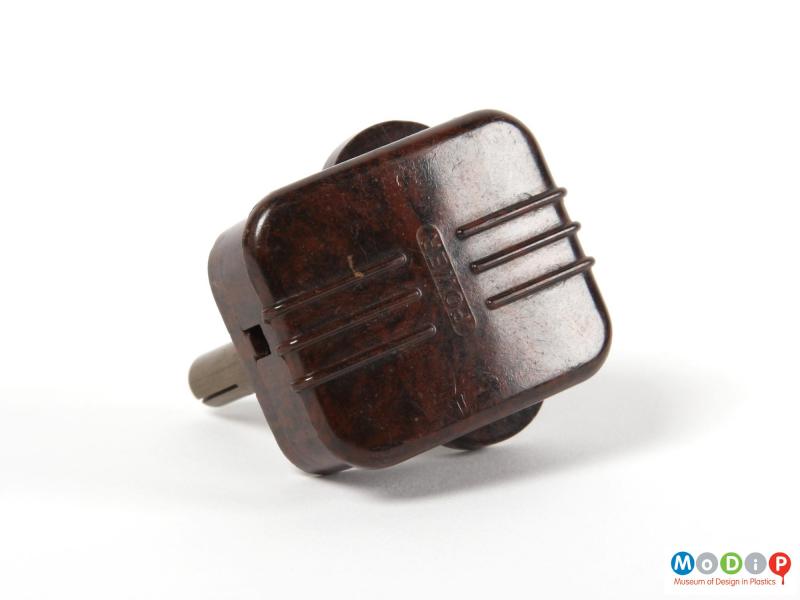 Rear view of a 3-pin plug showing moulded ribbing on the back of the plug and the moulded inscription.