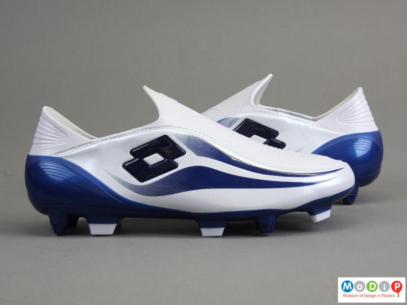 Side view of a pair of football boots showing the moulded studs in the base.