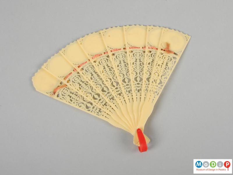 Rear view of a hand fan showing the pierced-style decoration.