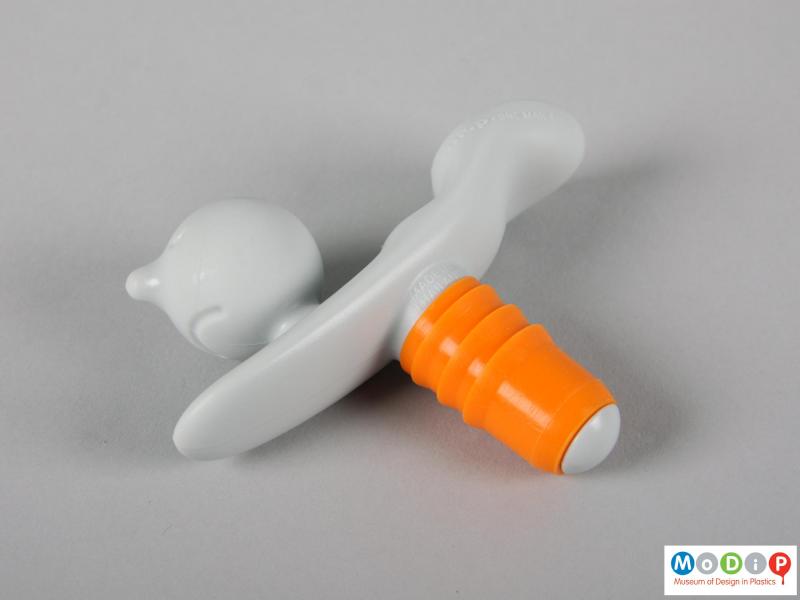 Side view of a bottle stopper showing the face and arms.