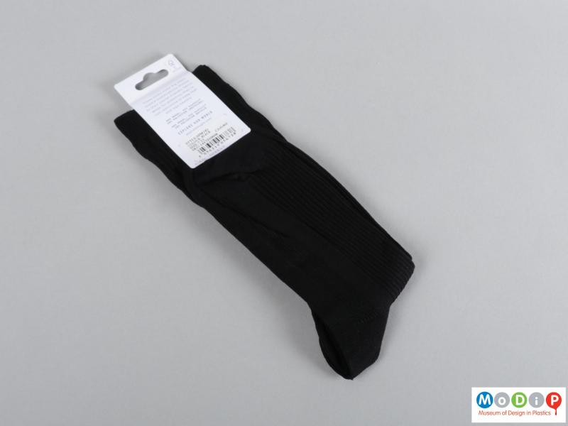 Rear view of a pair of socks showing the sock and packaging.