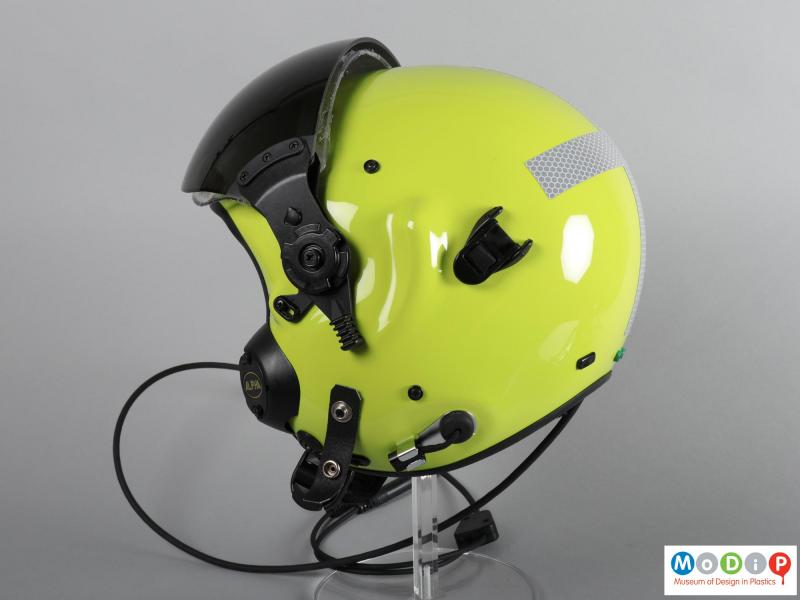 Side view of a helmet showing the yellow shell and black attachments.