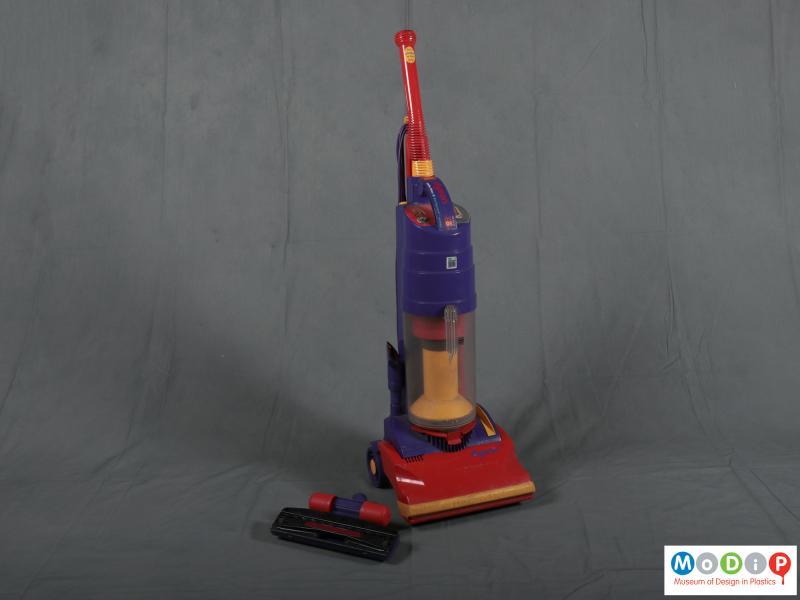 Front view of a vacuum cleaner showing the upright shape and separate tool.