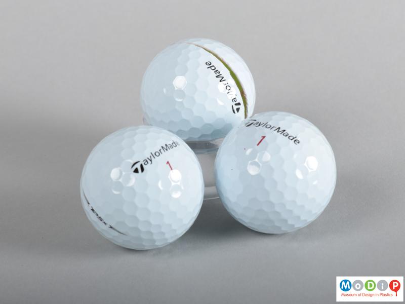Front view of three golf balls showing the surface dimples.