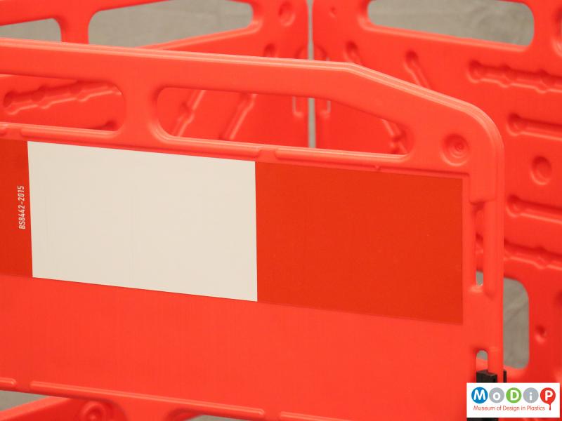 Close view of a barrier showing the red and white visibility tape.