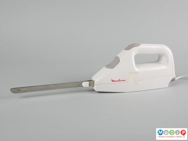 Side view of and electric carving knife showing the blades attached.