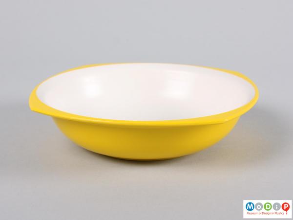 Side view of a bowl showing yellow outer and white inner surface.