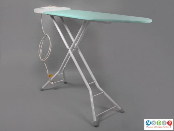 Side view of a Thermogem Ironing System showing the ironing board with the x frame at the base.