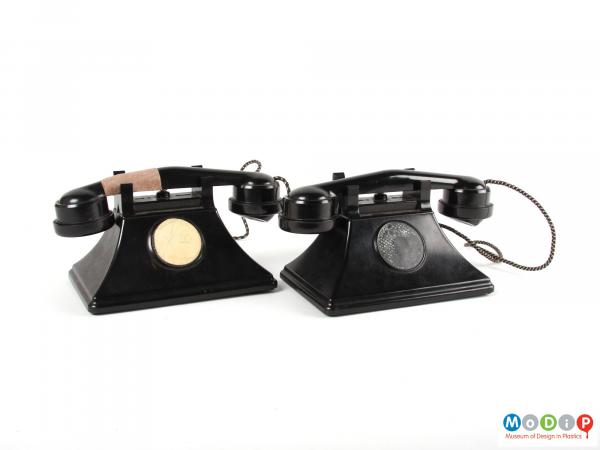 Front view of a pair of toy telephones showing the receivers across the top.