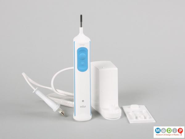 Front view of an electric toothbrush showing the body and charging unit.