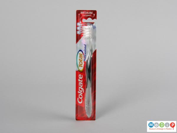 Front view of a packaged toothbrush showing the ergonomic shape of the handle and head.