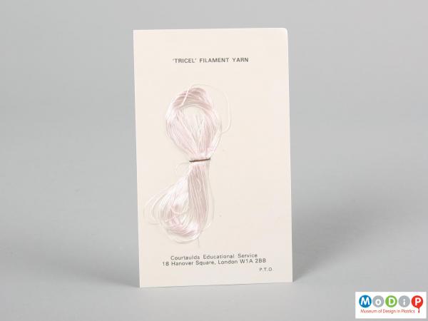 Front view of a fabric sample card showing the material stapled to the card.