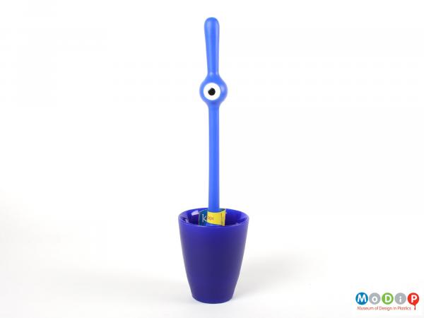 Front view of a toilet brush showing the brush standing it the holder.