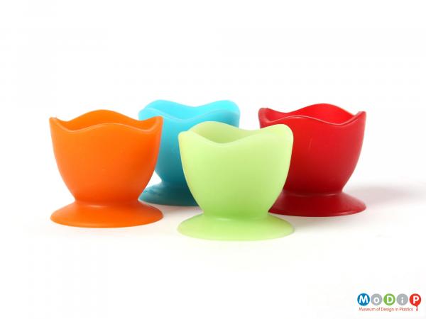 Side view of a set of Colin Ross egg cups showing the green and orange cups at the front with the blue and red cups behind.