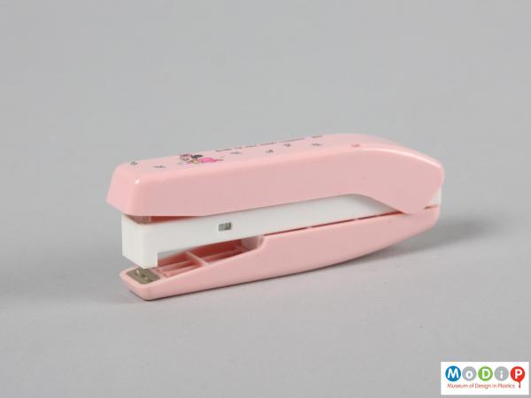 Side view of a stapler showing the pink and white body.
