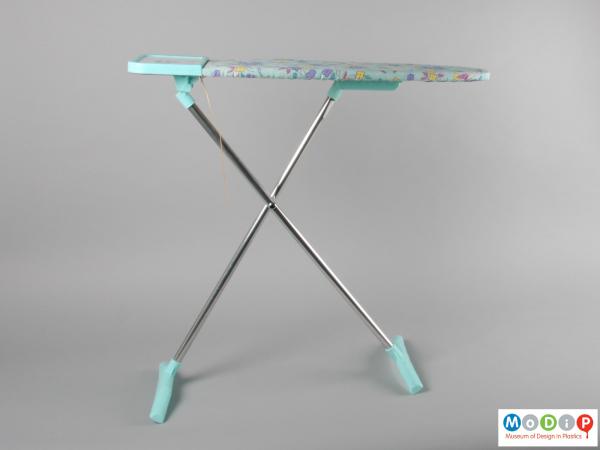 Side view of a toy ironing board showing the crossed legs.