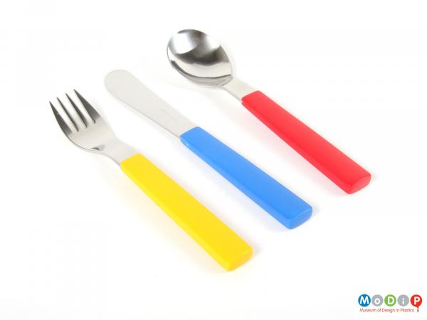 Top view of a cutlery set showing the primary colours of the handles.