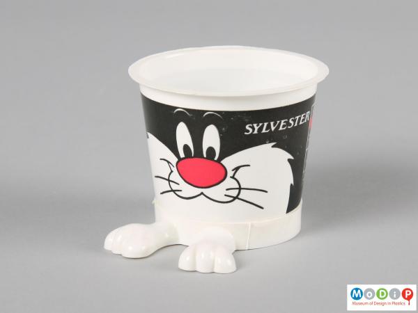 Side view of a Sylvester yoghurt pot showing the protruding legs at the bottom and printed face.