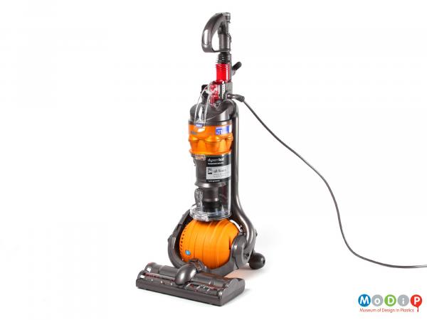 Side view of a Dyson DC24 All Floors vacuum cleaner showing the upright cleaner with its orange ball.