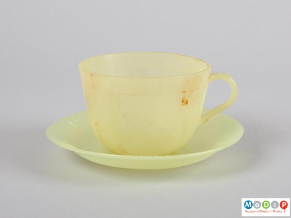 Side view of a cup and saucer showing the rounded handle.
