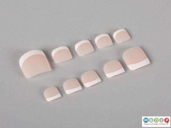 Top view of a set of false toenails showing some of the different sizes.