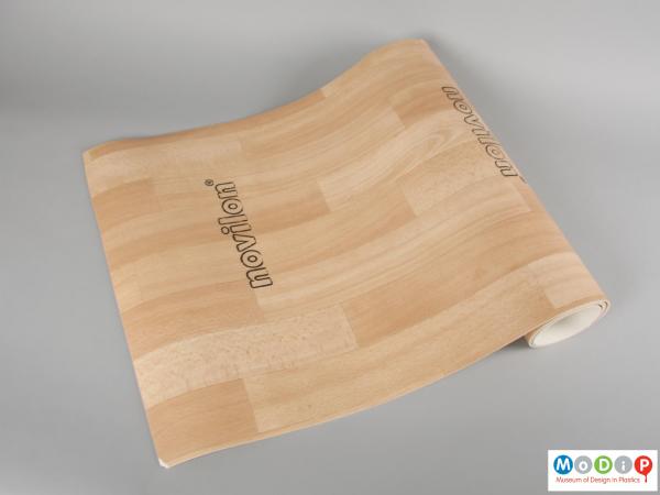 Side view of a sample of flooring material showing the printed wood block patterning.