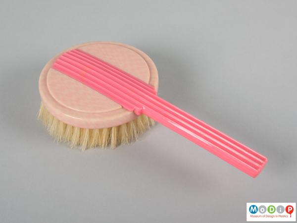 Top view of a brush showing the dark pink handle.