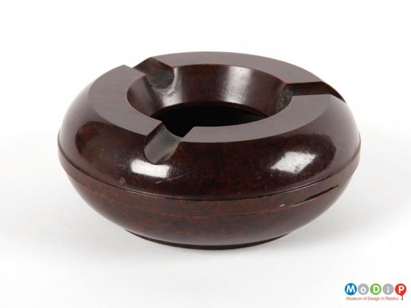 Side view of an ashtray showing the flat top and base to the circular shape. 