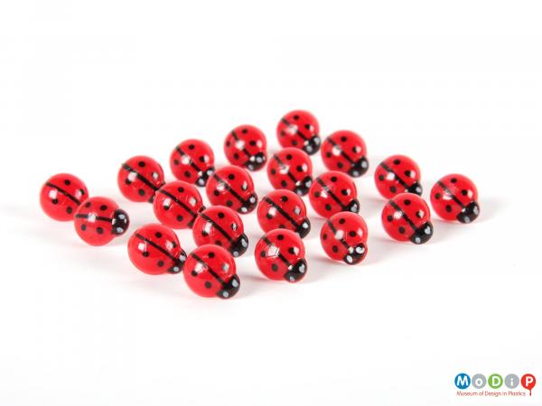 Top view of a set of drawing pins showing the red, black and white tops.