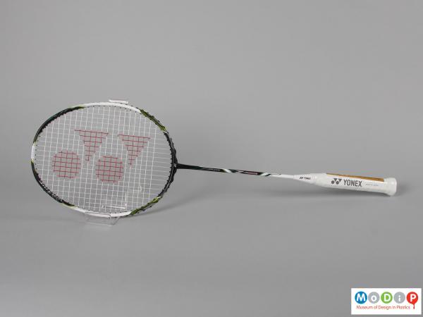 Side view of a badminton racket showing the egg shaped head and long, thin handle.