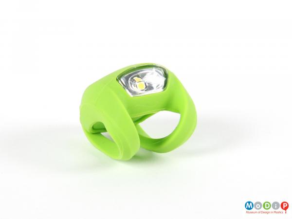 Front view of a bike light showing the white lens and green body.