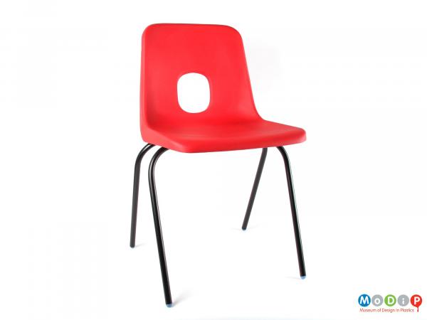 Front view of a chair showing the black legs and red seat.