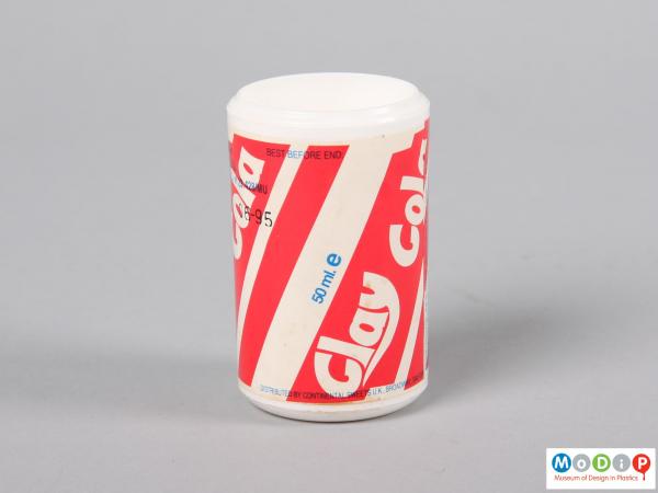 Side view of a drink container showing the cylindrical shape and paper label.