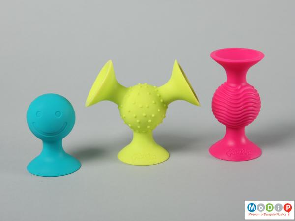 Side view of a set of three suction toys showing the colours and textures.