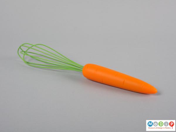 Side view of a whisk showing the green ballon and orange handle.