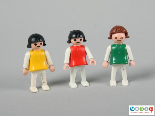 Front view of three female child figures showing the simple body shapes.