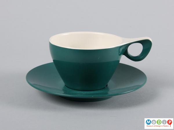 Side view of a cup and saucer showing the elegant handle.