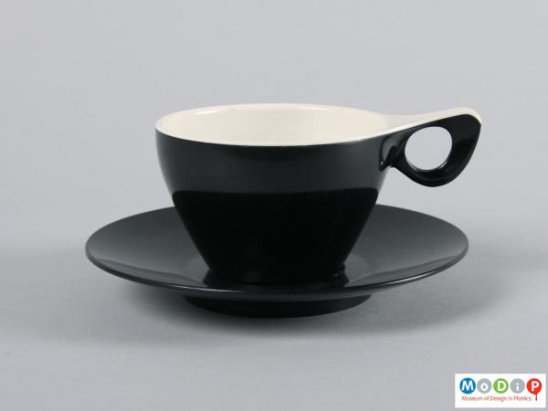 Side view of a cup and saucer showing the elegant handle.