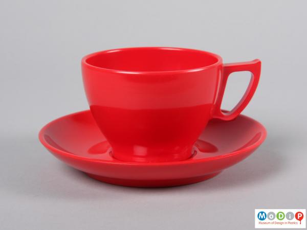 Side view of a cup and saucer showing the angular handle.