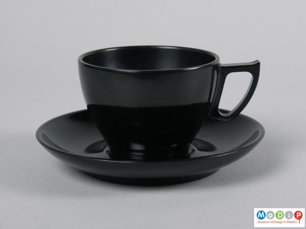 Side view of a cup and saucer showing the angular handle.
