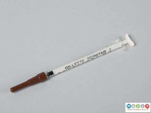 Side view of a syringe showing the needle cover.