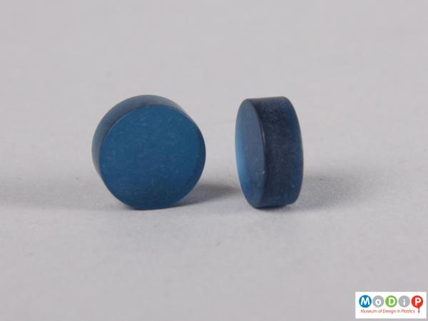 Side view of two blue contact lens buttons showing the thickness.