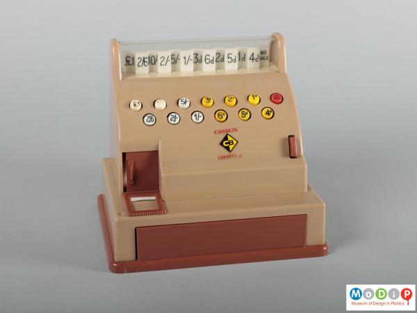 Front view of a toy till showing buttons and tabs.