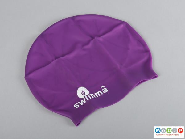 Side view of a swimming cap showing the printed logo.