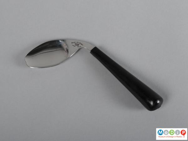 Side view of a spoon / fork showing the shaped handle and the double-pointed bowl.