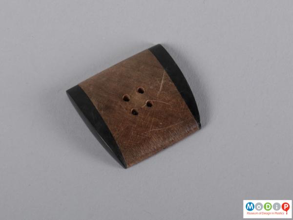 Front view of a button showing the asymmetric shape.
