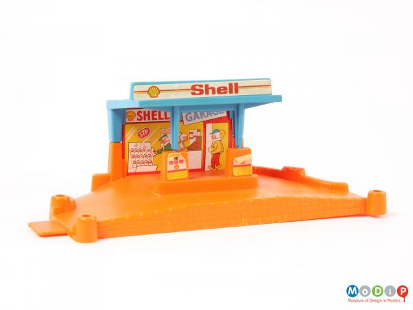 Front view of a toy garage showing the orange base, blue roof, and sticker details.