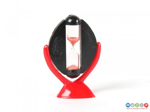 Side view of an egg timer showing the red stand and the black side of the rotating panel.