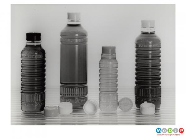 Scanned image showing four bottles and their related lids.