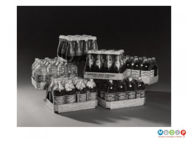 Scanned image showing 6 shrink wrapped crates of vinegar bottles.